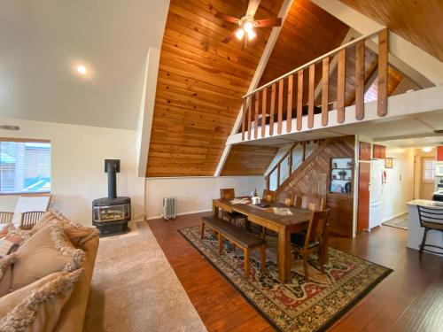 uma sala de estar com uma mesa e um fogão em Skyline Chalet em Forest Lakes Estates
