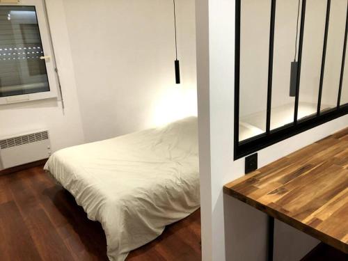 Habitación pequeña con cama y ventana en Gare - Elégant appartement pour pros ou touristes en Chambéry