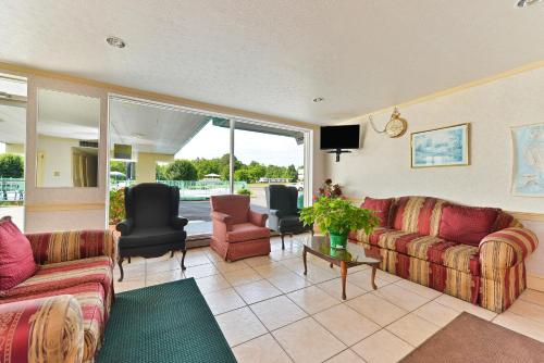 ein Wohnzimmer mit Sofas und Stühlen sowie einem TV in der Unterkunft Americas Best Value Inn Suites South Boston in South Boston