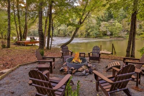 a group of chairs around a fire pit next to a river at Crescent Moon on the River in Ellijay