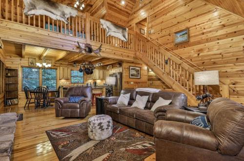 a living room with leather furniture in a log cabin at Crescent Moon on the River in Ellijay