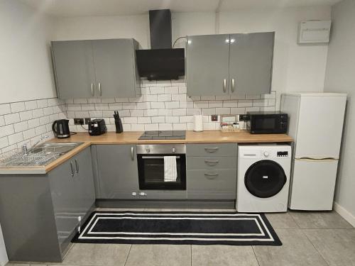 eine Küche mit Spüle, Waschmaschine und Trockner in der Unterkunft Nariken Apartments, Cardiff City Center in Cardiff