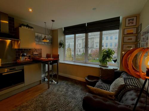 eine Küche und ein Wohnzimmer mit einem Sofa und einem Tisch in der Unterkunft Town Hall View in Barnsley
