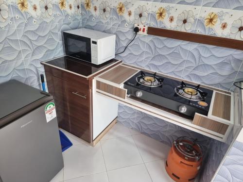 a small kitchen with a stove and a microwave at Finland in Migori