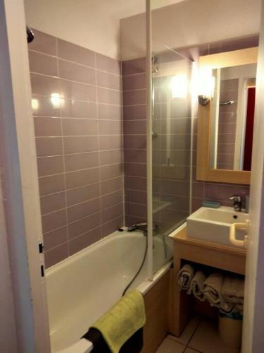 une salle de bain avec une baignoire et un lavabo dans l'établissement Appart 4 à 5 Pers face au golf 700m de l'océan, à Moliets-et-Maa