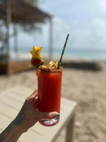 a hand holding a drink with a star on it at Coral De Fuego Isla Fuerte in Isla Fuerte