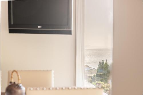 a television on a window with a view of the ocean at Apartamentos Rurales de Abelleira in Muros