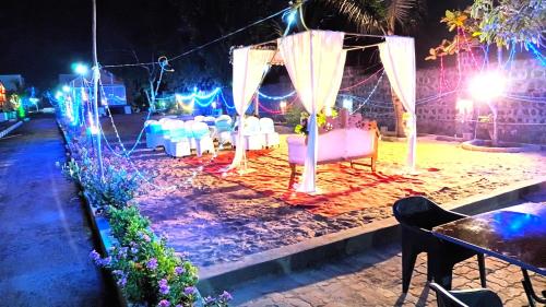 an outdoor wedding with white tables and chairs at night at Chan Beach Resort & Hotel in Bahūr