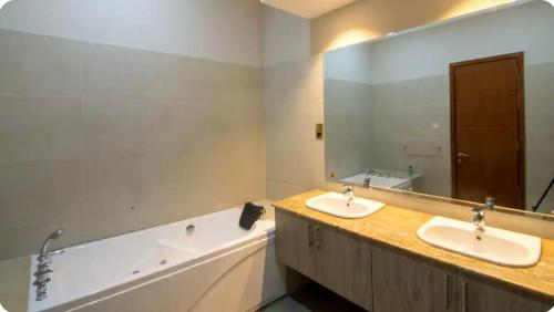 baño con 2 lavabos y espejo grande en Palm House en Nairobi