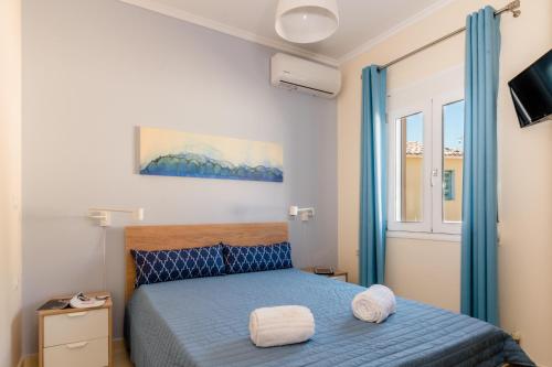 um quarto com uma cama azul e uma janela em Vicky's Lovely Family Home em Argostoli