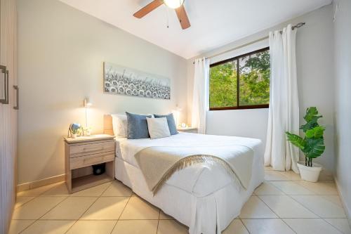 a white bedroom with a bed and a window at Flor de Limon 2 in Coco