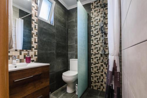 a bathroom with a toilet and a sink at Vicky's Lovely Family Home in Argostoli