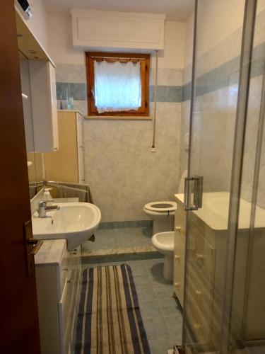 een badkamer met een wastafel en een toilet bij Via del tombolo in Grosseto