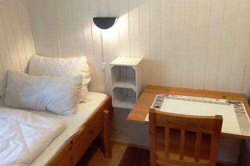 Kleines Zimmer mit einem Bett, einem Tisch und einem Schreibtisch. in der Unterkunft Holiday home Hunning in Hünning