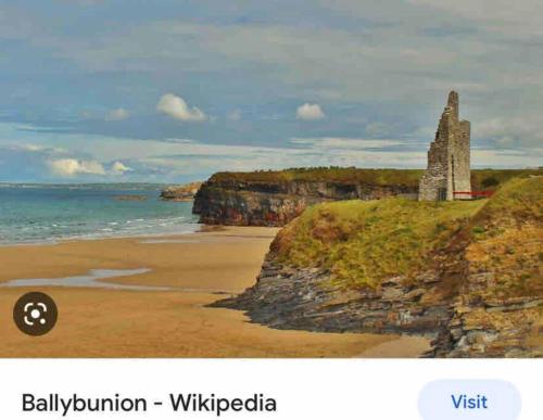 a painting of a beach with a rock formation at Hannahs Cottage 