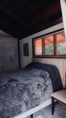 una camera con letto e finestra di CURTA! | Casa dos Pássaros - CA (Piso Superior) a Campo Alegre