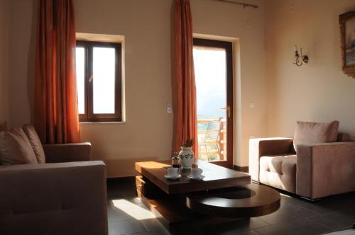 a living room with a couch and a coffee table at Melies Hotel in Kokkinórrakhi