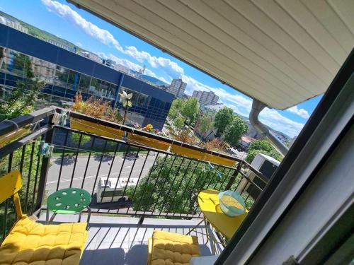 クラグイェヴァツにあるApartman Swissの通りの景色を望むバルコニー(黄色い椅子付)