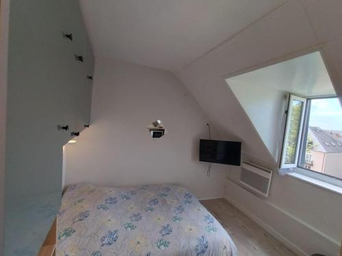 a small bedroom with a bed and a window at Petit nid à Corbeil-Essonnes in Corbeil-Essonnes