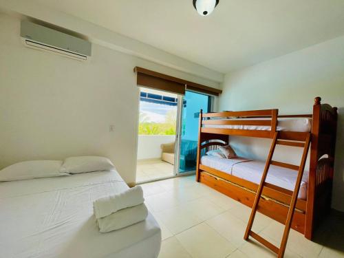 a bedroom with two bunk beds and a balcony at Playa Blanca Founders 1 in Río Hato