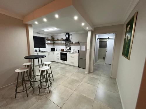 a kitchen with a table and stools in it at Addai Self Catering Brackenfell Durbanville area in Cape Town