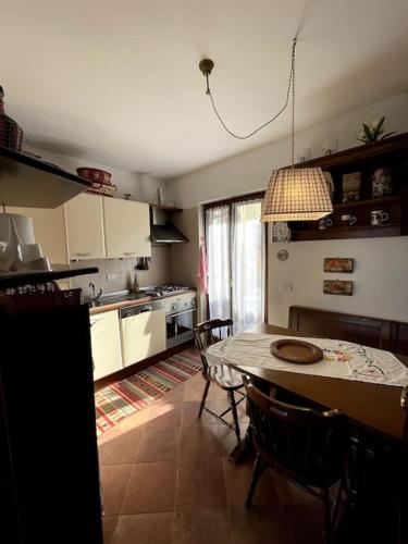 eine Küche mit einem Tisch und Stühlen sowie ein Esszimmer in der Unterkunft Il Giardino di Marisa in Pescocostanzo