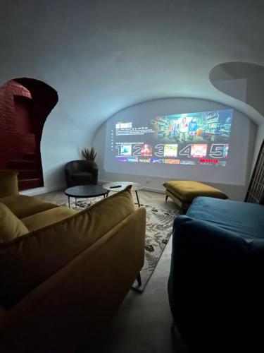 sala de estar con sofás y TV grande en La Maison Des Petits Sablon, en Amiens
