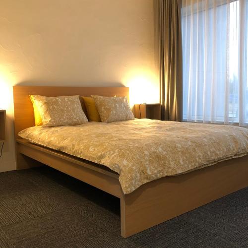a bedroom with a bed with two pillows and a window at Ring Stop Holiday Apartment 11 in Sigulda