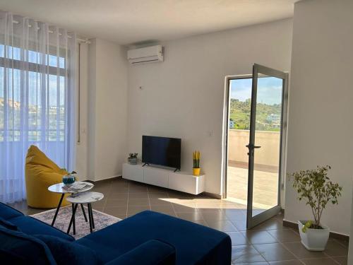 a living room with a blue couch and a mirror at Gibel Apartments in Golem