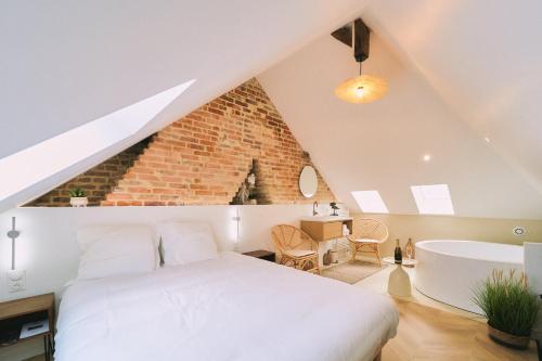 a bedroom with a white bed and a bath tub at Elégante maison amiénoise - jacuzzi, home-cinéma, proche gare - La Maison Des Petits Sablon in Amiens