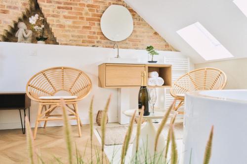 ein Wohnzimmer mit 2 Stühlen und einem Tisch in der Unterkunft La Maison Des Petits Sablon in Amiens