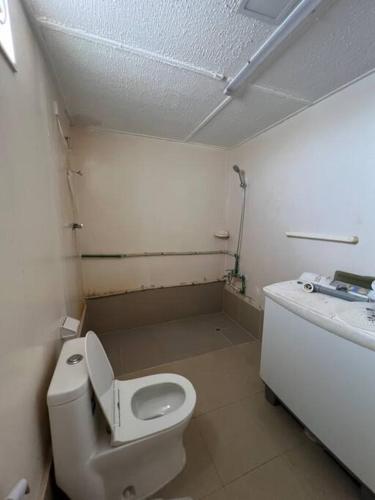 a small bathroom with a toilet and a sink at Two rooms and one living room in Delma island in Da‘sah