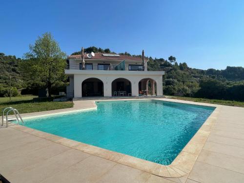 una gran piscina frente a una casa en Antinea Olympian Villa en Archea Pissa