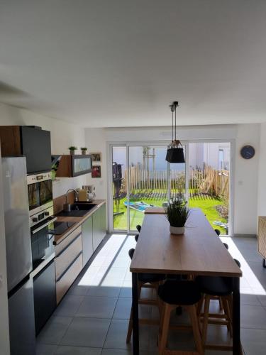 une cuisine avec une table et une vue sur l'océan dans l'établissement Charmante maison entre mer et forêt, à Saint-Jean-de-Monts