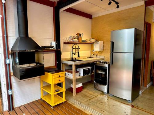 uma cozinha com um frigorífico de aço inoxidável e um lavatório em Cabana do Araujo em Paraty