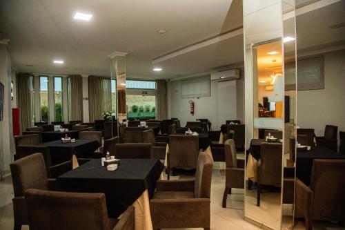 um restaurante com mesas e cadeiras num quarto em Dallas Hotel Premium em Altamira