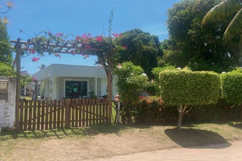 einen Zaun vor einem Haus mit Blumen in der Unterkunft Casalagorios - ilha de Itaparica - Berlinque in Vera Cruz de Itaparica