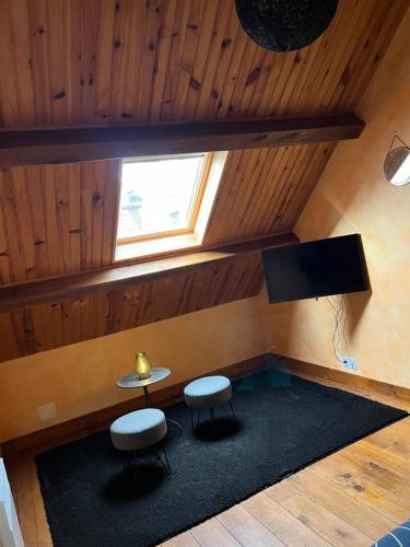 une chambre avec une table, deux tabourets et une télévision dans l'établissement Maison. Neung sur Beuvron. L’Orchidée, à Neung-sur-Beuvron