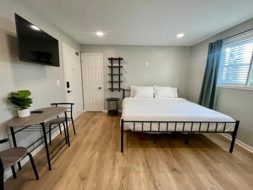 a bedroom with a bed and a table and a tv at Cathedral Studio in Omaha