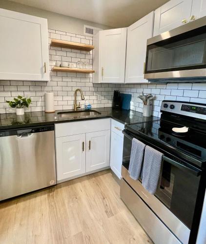 a kitchen with stainless steel appliances and white cabinets at Cathedral Studio in Omaha