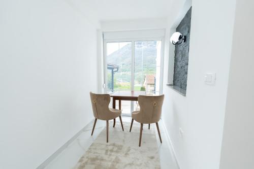 a dining room with a table and chairs and a window at Ema Apartments in Plav