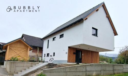 a white house with a gambrel roof at Bubbly Apartment in Bled