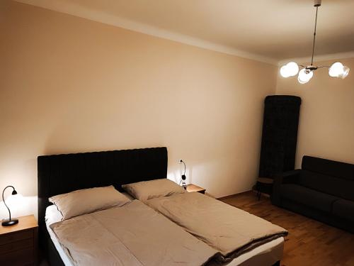 ein Schlafzimmer mit einem Bett und einem schwarzen Sofa in der Unterkunft Quiet Central in Ljubljana