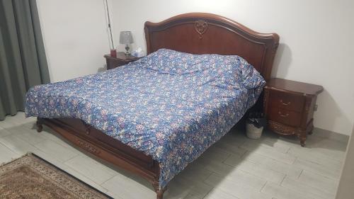 a bed with a blue comforter in a bedroom at M apartment in Kuwait