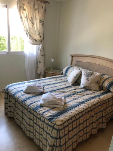a bedroom with a bed with two towels on it at La Manga Club Villa in Atamaría