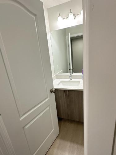 y baño con lavabo y espejo. en Open modern concept 2BR basement, en Calgary
