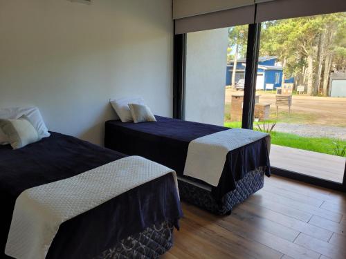 a bedroom with two beds and a large window at Hermosa Casa a 5min de la playa (La Pina) in Costa Esmeralda