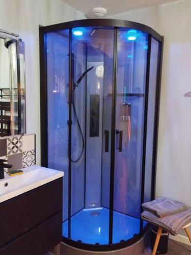 La salle de bains est pourvue d'une douche avec des lumières bleues. dans l'établissement Le Paradis, à La Roche-Blanche