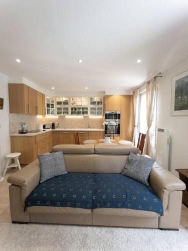 un salon avec un canapé et une cuisine dans l'établissement Appartement Paris La Défense Puteaux, à Puteaux