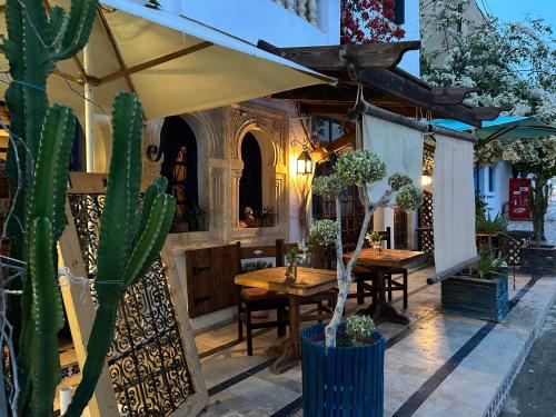Harqalah的住宿－L'artisan，餐厅设有木桌和大伞